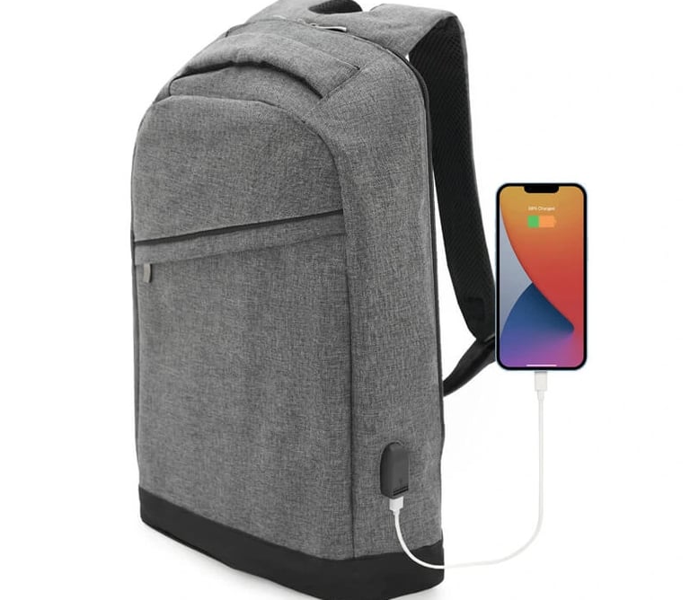 Grey anti-theft laptop backpack with a built-in USB charging port connected to a smartphone.