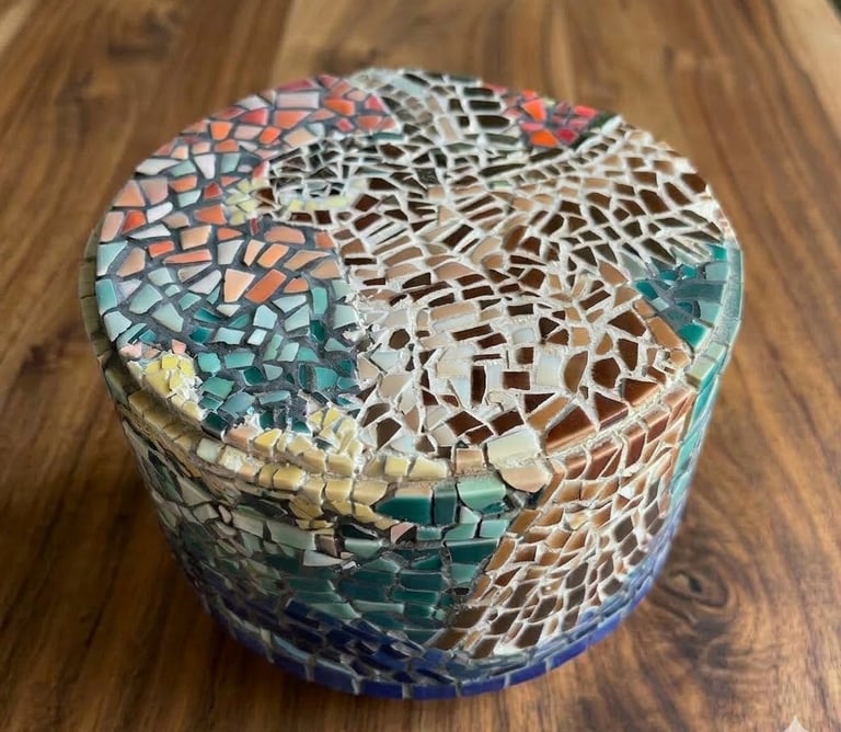 Top down view of "Vessel of Remembrance" mosaic showing airborne falcon & multicolored ceramic tiles