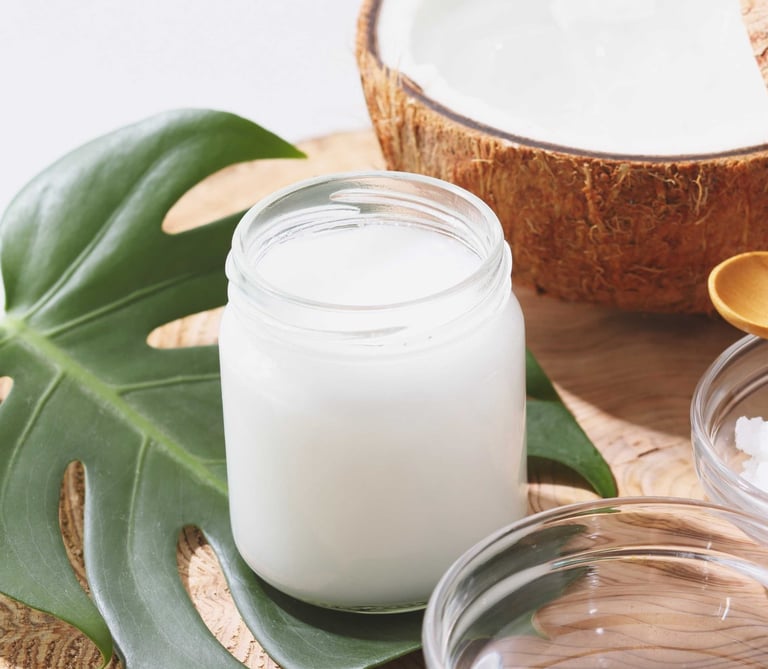 Fotografia de un recipiente de aceite cristalizado de coco junto a unos cocos