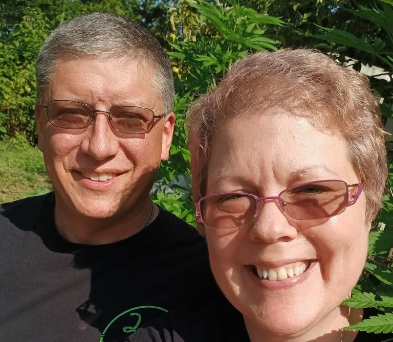 a man and woman sitting in front of a hemp plant