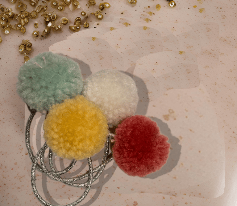 a pom pom decorated hair elastic band
