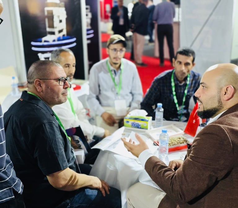 Business professionals at an international trade show discuss and network at a booth, showcasing global commerce and