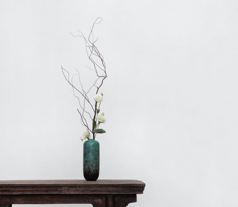 Photo E-commerce d'un vase élégant vert et noir placé sur le bord d'une table en bois avec 3 roses