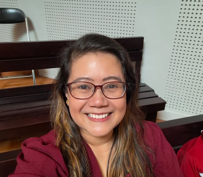 a woman in a red shirt and glasses sitting at a table