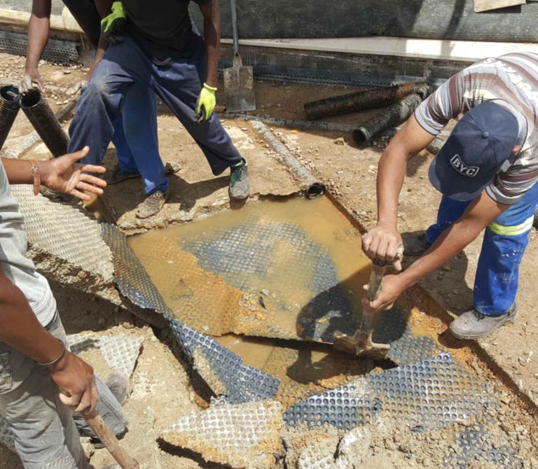 Engineers inspecting damaged concrete slab for water ingress