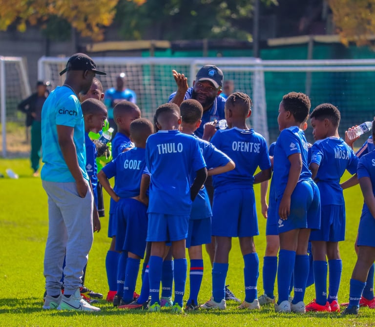 a group of young boy soccer players standing in a circle