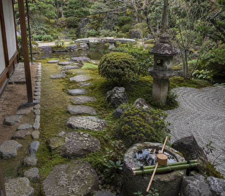 Traditional Japanese zen garden with stepping stones, stone lantern, and tsukubai water basin.