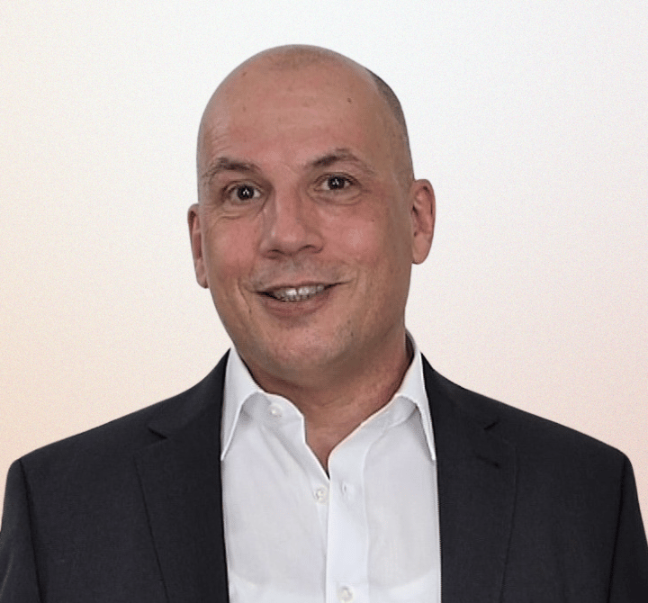 Professional Heinz Roelfs in a black suit and white shirt smiling for a business headshot.