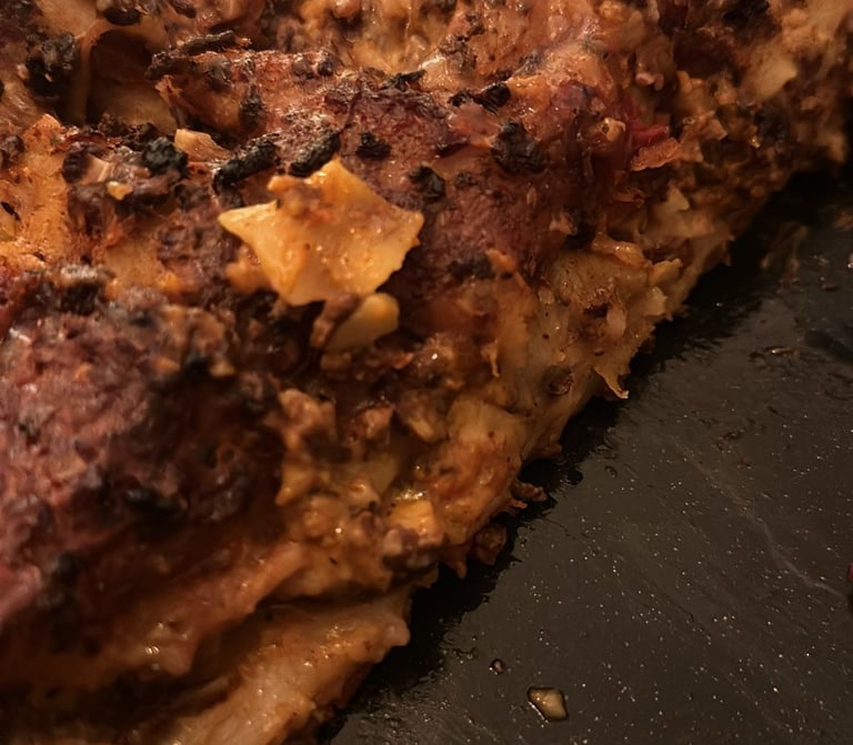 Homemade baked lasagna with a crispy, charred cheese crust and layers of rich meat sauce.