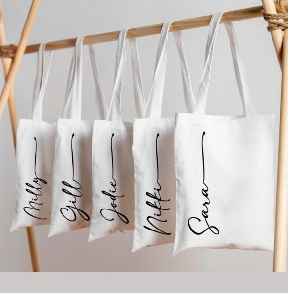 a row of tote bags with customized name 