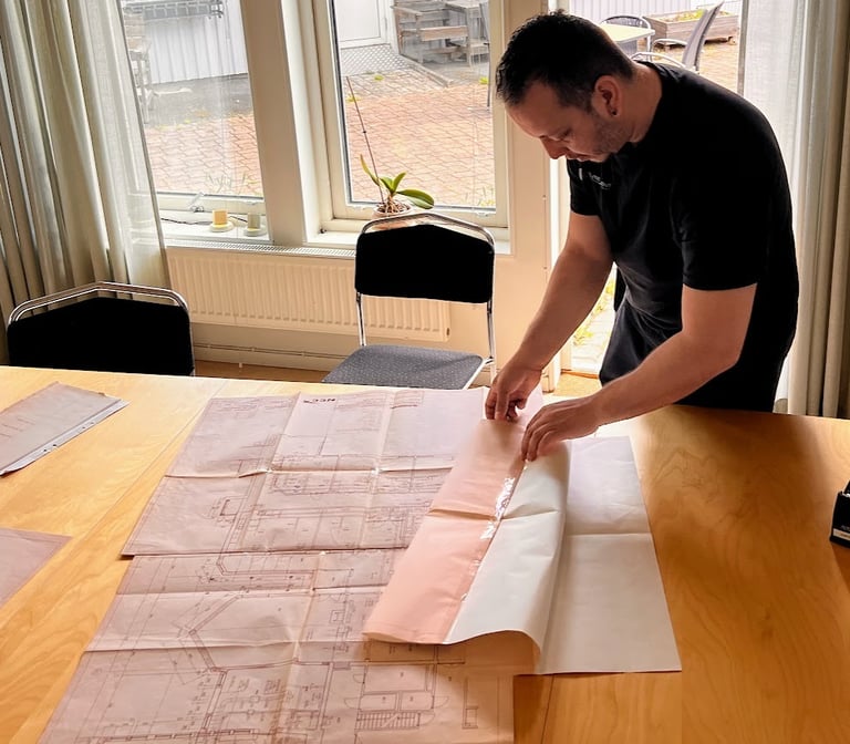 Ventilationsteknikern läser ritningar, och förbereder sig inför injustering.