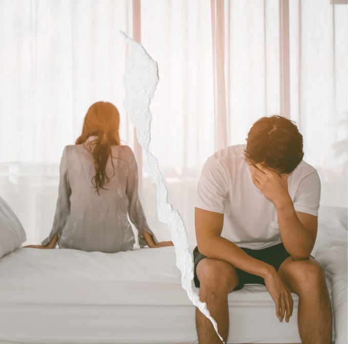 Image of a couple in distress. Each partner is sitting on a different side of bed, with their back against each other.