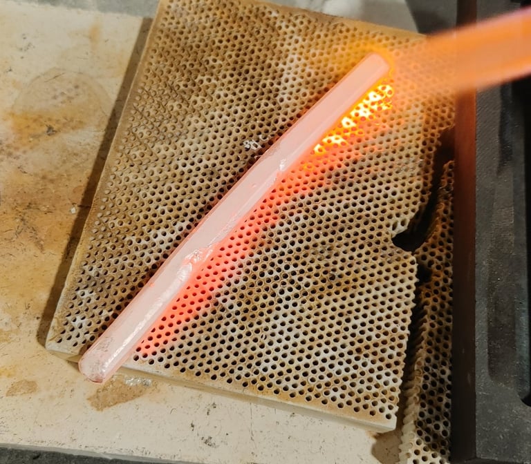 Hot silver piece being quenched in water after heating.