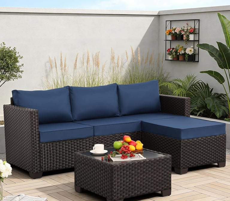 Modern outdoor sectional sofa with navy blue cushions and a matching wicker coffee table on a patio.