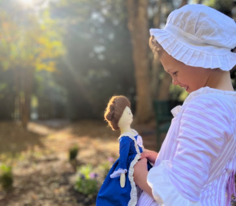 a little girl in a dress and bonnet hat
