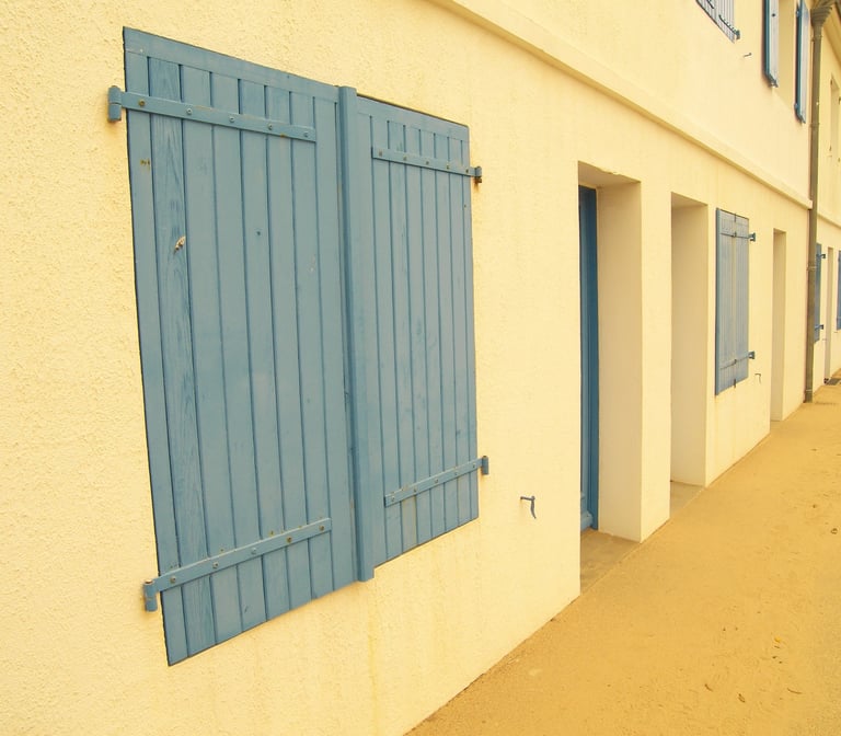 façade orange avec des volets en bois bleu 