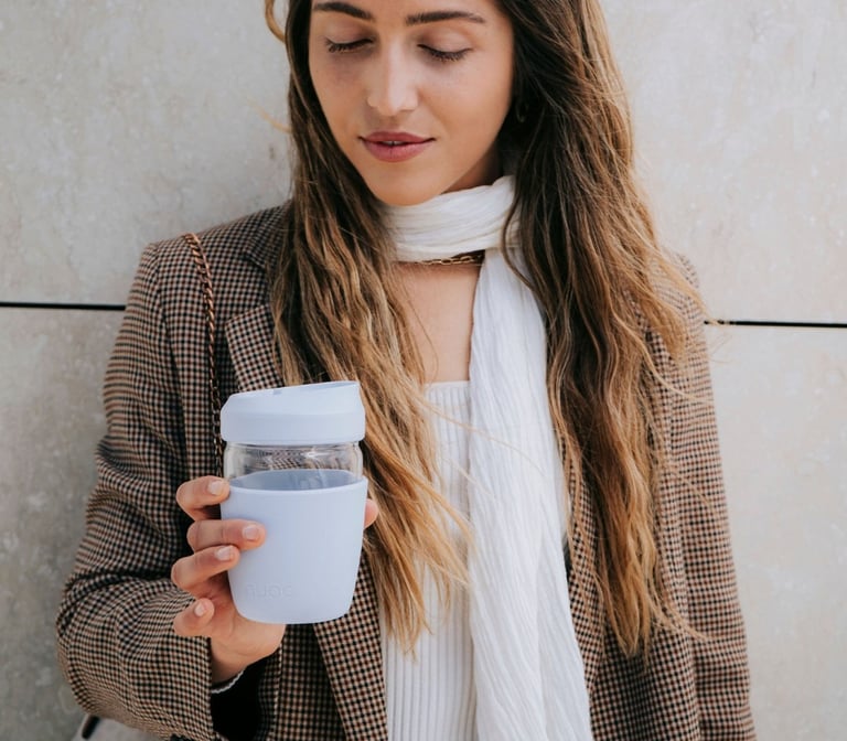 daugkartinis kavos puodelis moters rankose