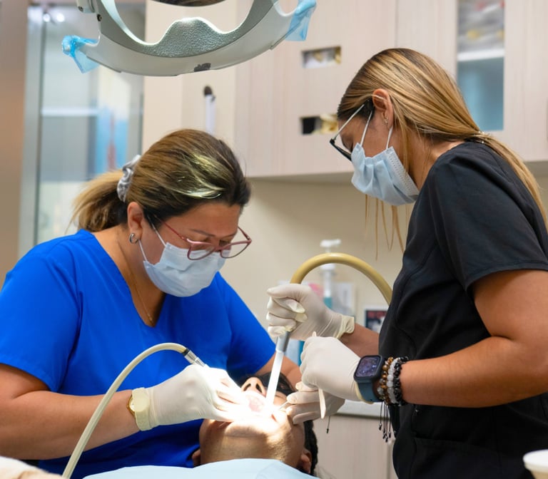 Dental implant procedure performed by a dentist and assistant in a NYC dental office