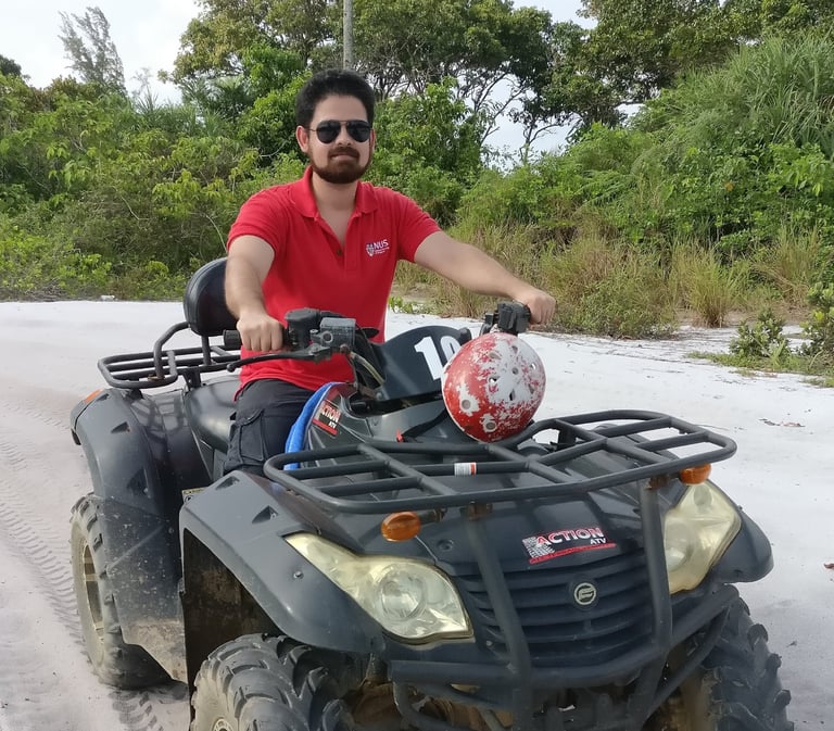 Bhargav sitting on an ATV at a beach in Indonesia
