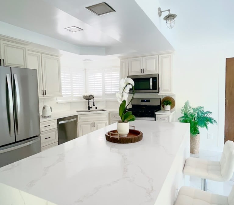 a kitchen with a large counter top and chairs