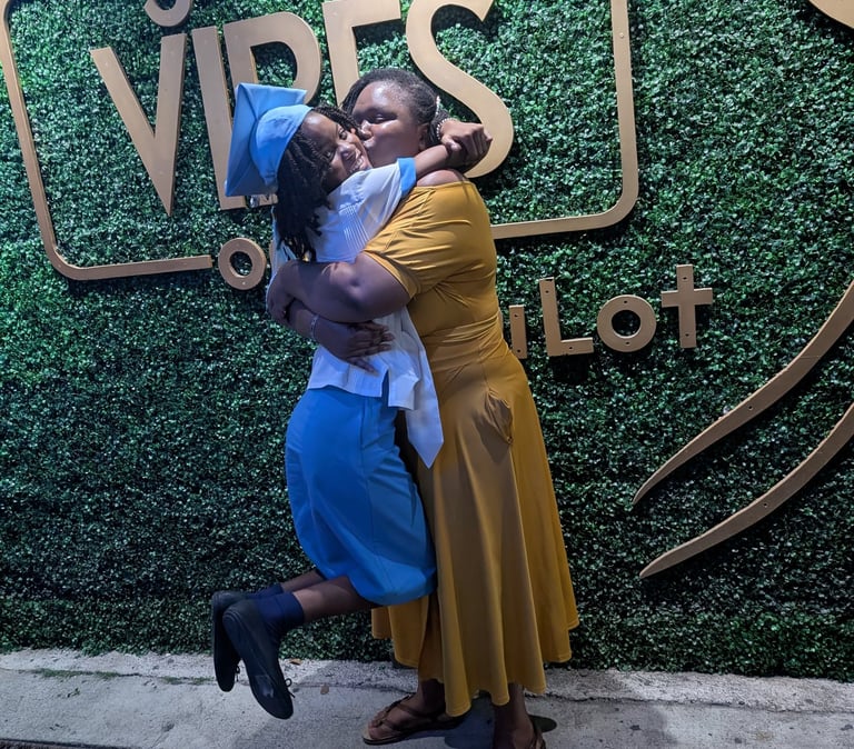 two women hugging each other in front of a sign that says good vibes