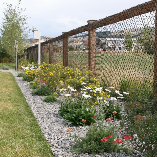 a fenced in area with a fence and flowers