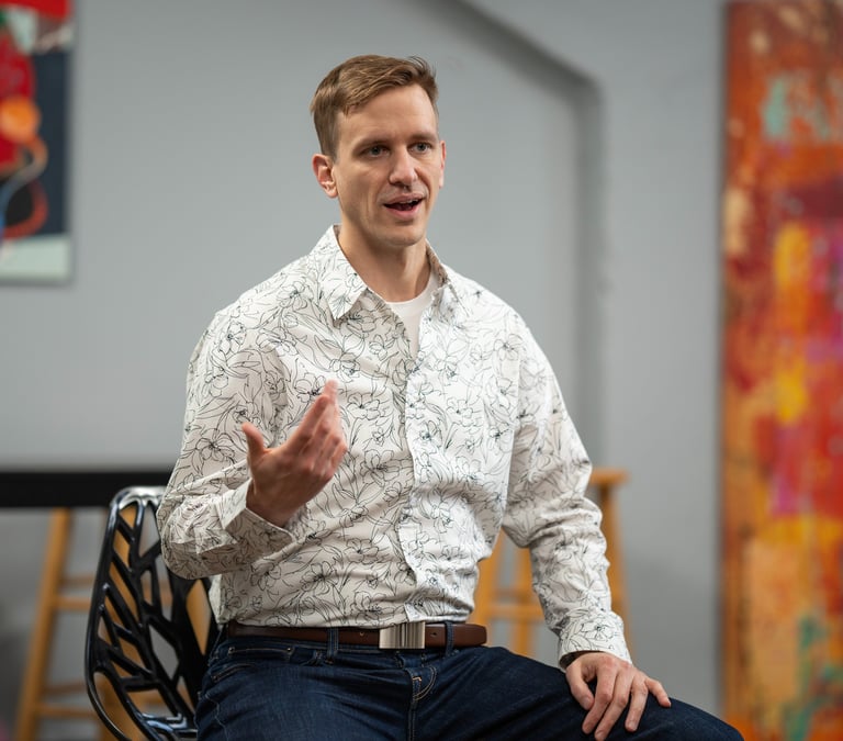 Remy sits gesturing during a small group talk
