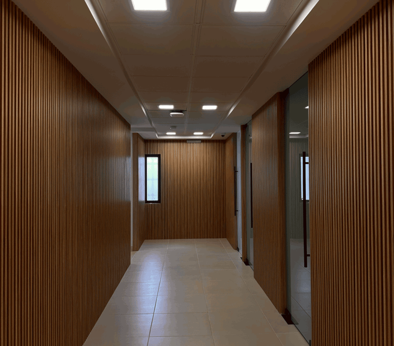 Pasillo con acabado de madera en muros y plafón con luminarias LED | KARÄNA