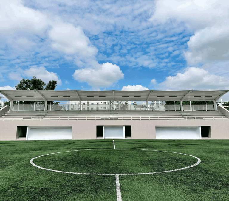  Gradas techadas frente a cancha deportiva sintética | KARÄNA