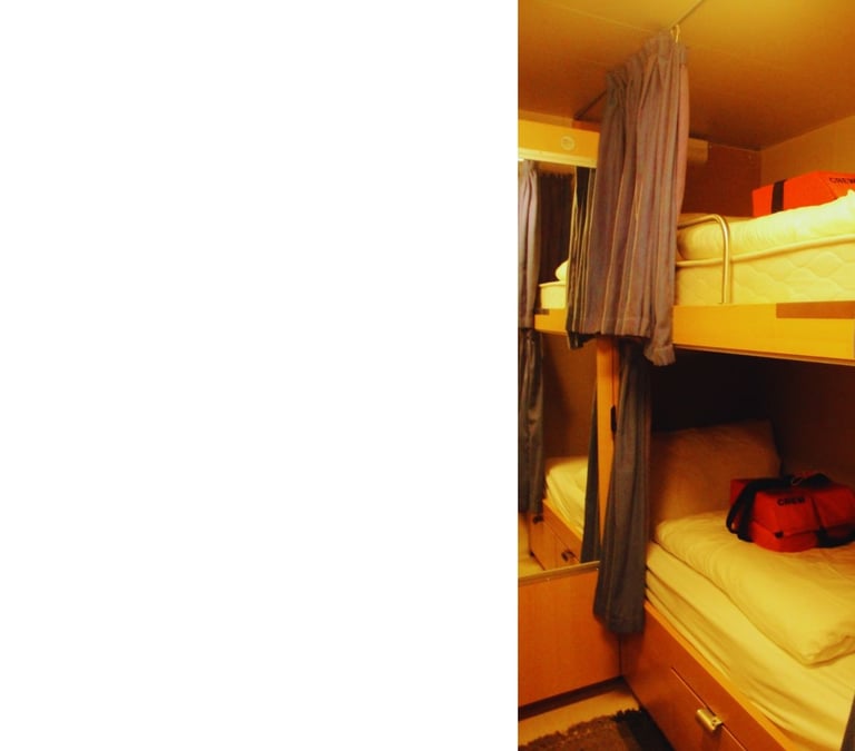 Primeira cabine da autora a bordo, com cama, TV e telefone, oferecendo conforto básico para descanso