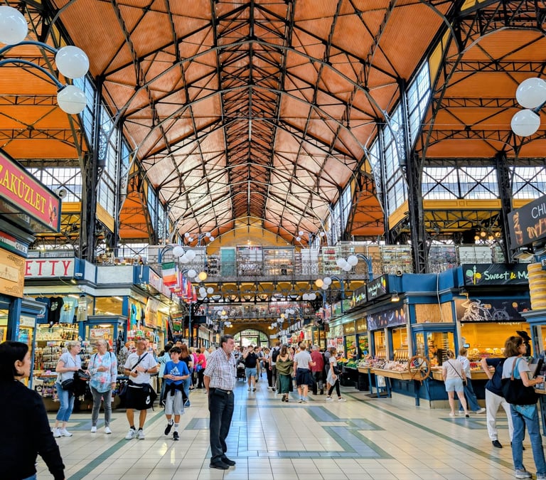 Tourists walking between the many stalls in the Central Market Hall, Budapest, Hungary.