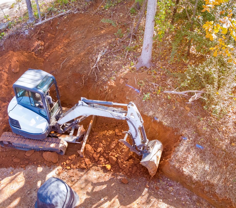 bobcat excavator digging dirt against side hill
