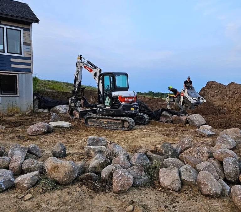 Bobcat Excavator and Bobcat mini excavator building a block retaining wall