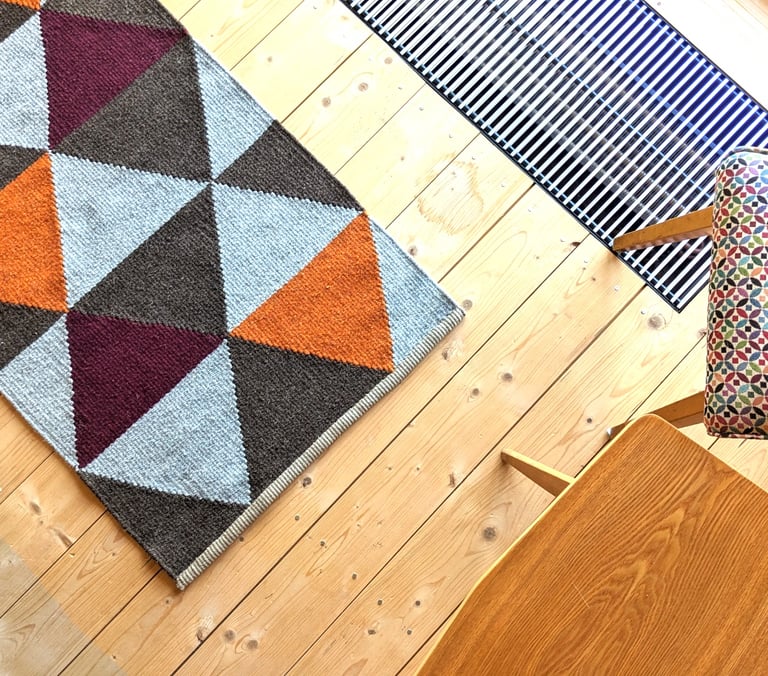 Modern handwoven kilim rug with geometric triangles in orange, burgundy and brown, adding warmth and