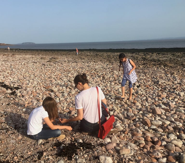 home educated children playing with mum on a beach