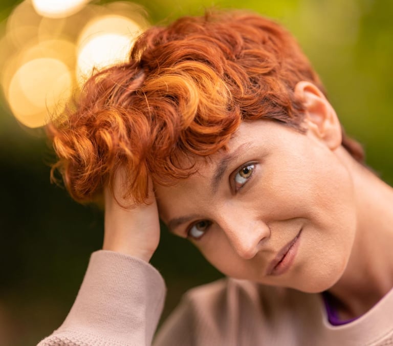 a woman with red hair and a pink sweater