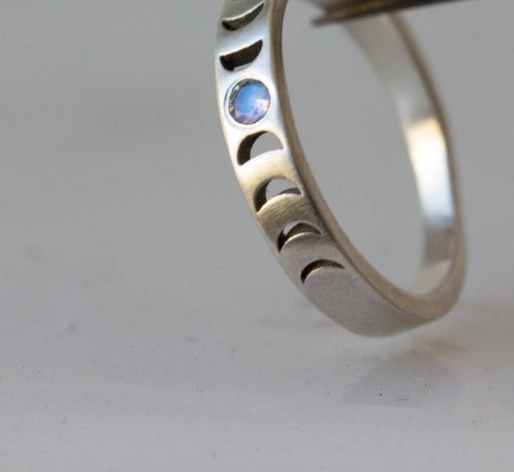 Anillo de fase lunar de plata con una piedra lunar azul y diseños de ciclo lunar grabado