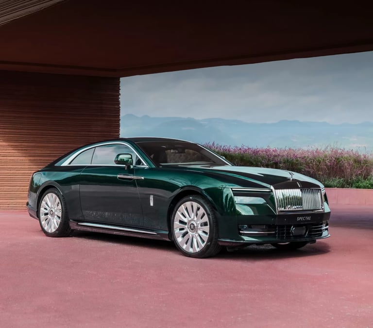 Rolls-Royce Spectre luxury electric coupe in deep green, parked in a scenic modern setting.