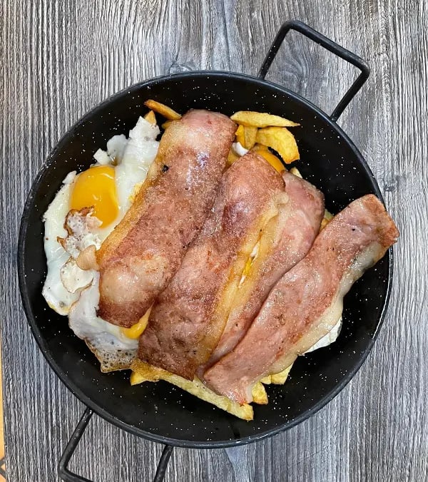 huevos rotos con patatas caseras y beicon frito