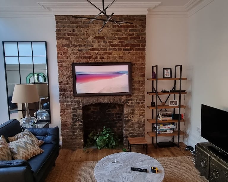 Professional installation of a Samsung Frame TV on an exposed brick wall with architectural cable co