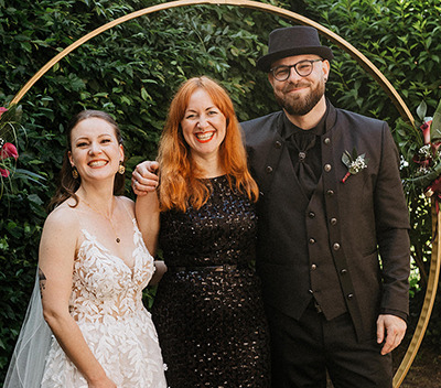 Alternative Wedding Hannover! ein strahlendes Hochzeitspaar mit einer glücklichen Rednerin in ihrer Mitte nach der Trauung