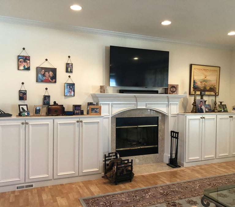 Custom fireplace surround with built-in cabinets and crown molding