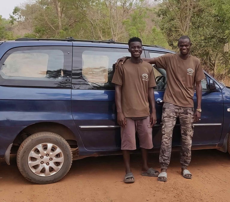 Two professional drivers of Birding Adventures Gambia standing next to the tour vehicle