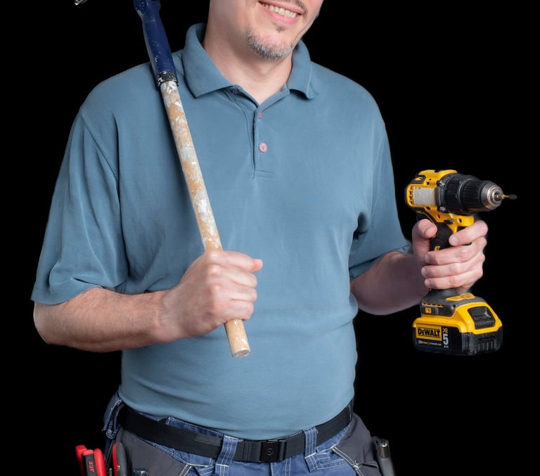 Cyd smiling and holding a paint roller and a drill
