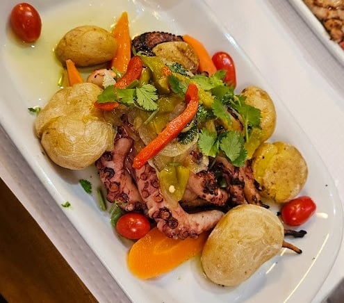a plate of food and a glass of beer on a table