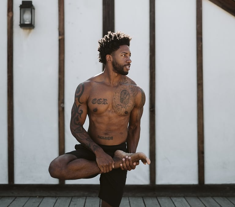 Hombre haciendo yoga, postura inicial Ardha Baddha Padmottanasana