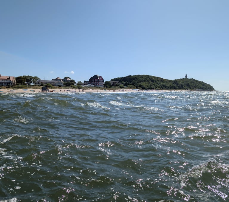 Choppy Baltic Sea waves crashing near the Hel Peninsula coastline on a sunny day