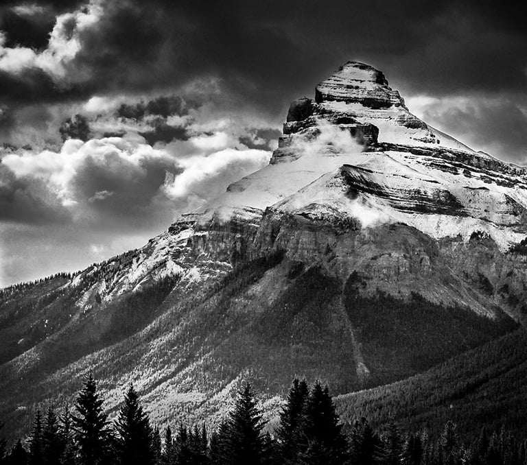 Charity Mountain in the Canadian Rocky Mountains, showcasing it's rugged snow covering and a dramtic sky