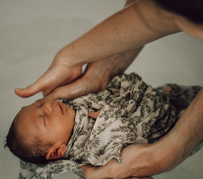 bain enveloppé bébé avec mains de papa