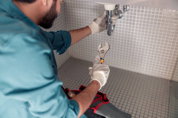 plumber aiming where he is going to slot his adjustable wrench to turn the pipe